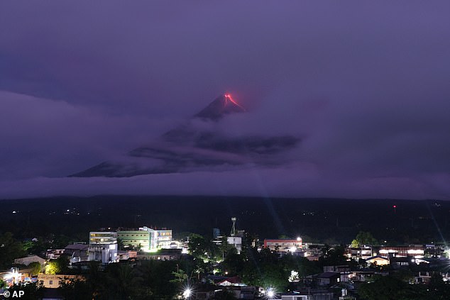 Green fireball and lava erupt simultaneously above Mount Mayon